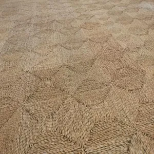 Handmade straw woven carpet detail texture, natural plant fiber geometric pattern close up.