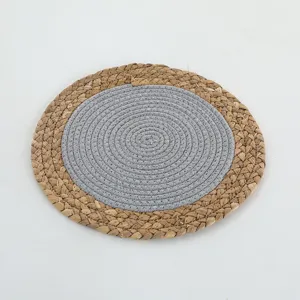 Gros plan détaillé du set de table rond tissé montrant la paille et la corde grise.