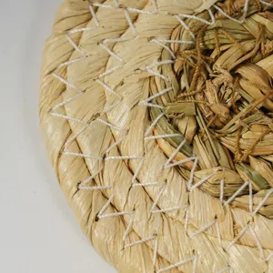 Close-up detail of hand-woven straw and corn husk placemat, showing natural texture and sturdy stitching.