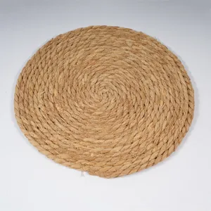 Natural straw woven placemat detail shot, handmade round heat insulation dining mat.