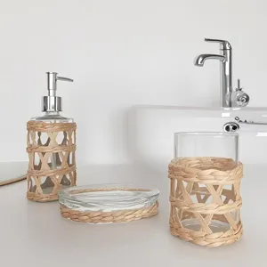 Ensemble de salle de bain en verre avec rotin, distributeur, porte-savon et gobelet.
