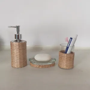 Ensemble d'accessoires de salle de bain en verre et paille tissée, détail distributeur.