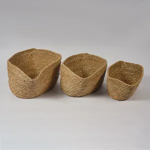 Detalle de cestas de almacenamiento de pasto marino tejidas a mano, juego de tres naturales.