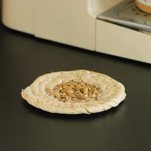 Handcrafted round straw coaster, natural corn husk woven heat-resistant mat for home dining table.