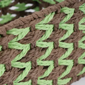 Detail view of handmade woven storage basket, brown and green paper rope texture, close-up.