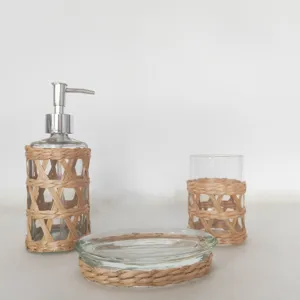 Ensemble d'accessoires de salle de bain en verre et rotin tissé, vue détaillée naturelle.