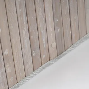 Gros plan detail du panier de rangement en lattes de bois bordure tisse bouton metal.