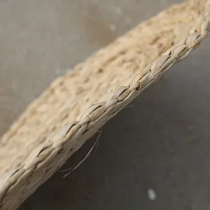 Detalle de mantel individual de paja, estera redonda de fibra vegetal natural para decoración.