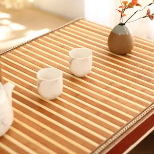 Handmade bamboo woven table detail with ceramic tea cups, pastoral style home decor surface.