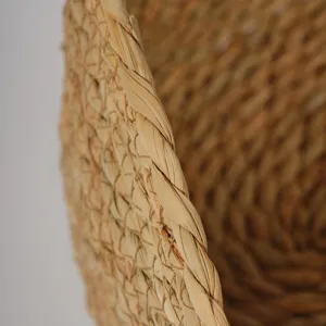 Cesta de almacenamiento de junco marino trenzado, detalle de textura de fibra natural.