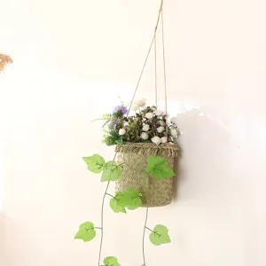 Hand-woven hanging flower basket detail showing artificial floral arrangement and trailing vines.