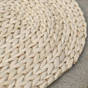Primer plano de la estera de paja natural tejida con textura detallada hecha a mano y diseño rústico.