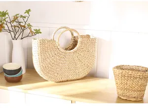 Handmade straw basket detail showcasing natural cattail grass weave, crescent shape with handles.