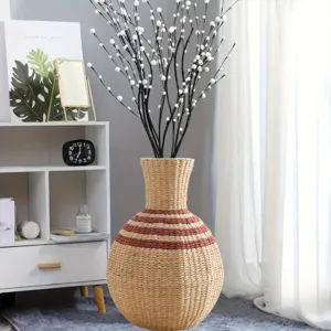 Handwoven seagrass belly vase with branches, rustic natural straw flower pot for home decor.