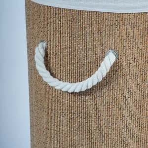 Close-up detail of woven laundry basket with cotton rope handles and bamboo texture for home.
