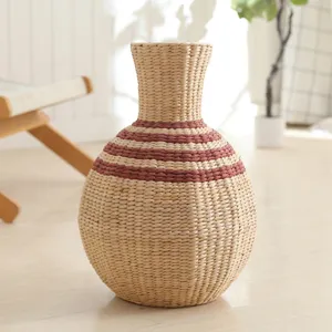 Handmade woven straw vase, natural plant fiber floral container for rustic tabletop home decor.