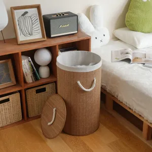 Round bamboo laundry basket with lid and rope handles for home organization and storage.