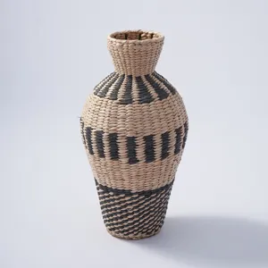 Handmade woven straw vase detail, natural water hyacinth fiber, unique black pattern.