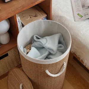 Round woven laundry basket with lid fabric liner and rope handles for home clothes storage.