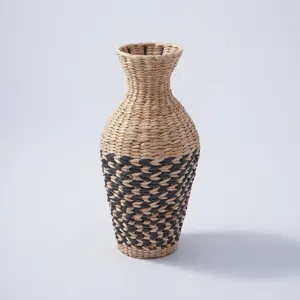 Handmade woven straw vase detail view, natural plant fiber desktop decorative floral container.