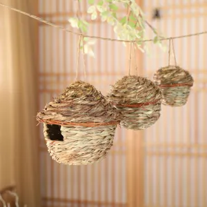 Handmade woven grass bird nest for pets, natural hanging birdhouse for breeding and cage decor.