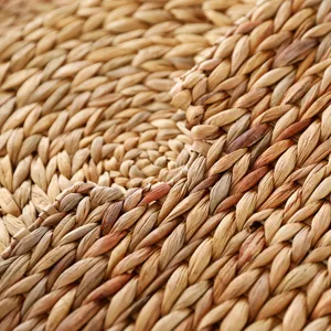 Detailed close-up view of a natural woven straw placemat, showing exquisite braided texture.
