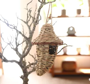 Handcrafted straw woven bird house detail, natural pet breeding nest hanging decoration for garden.