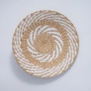 Close-up detail of the round woven straw wall hanging showing intricate spiral texture.