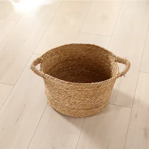 Handmade straw woven laundry basket detail shot, natural seagrass storage hamper for home.
