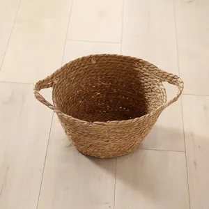 Handmade straw woven storage basket with handles for laundry and home organization.