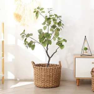 Handcrafted straw woven flower basket with artificial eucalyptus plant for home and office decor.