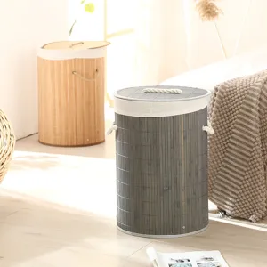 Vue détaillée du panier à linge cylindrique en bambou avec doublure en lin et poignées en corde.