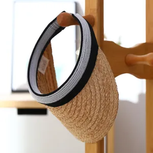 Detailed view of handmade raffia straw sun visor, empty top design with black trim.