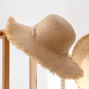 Handmade straw sun hat featuring delicate lace ties, showcasing natural woven texture and summer style.