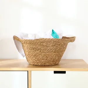 Handmade woven seagrass storage basket with handles, natural straw laundry hamper for home decor.