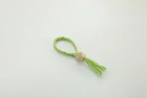 Handmade woven paper rope napkin ring with natural wooden bead and tassel detail for table decor