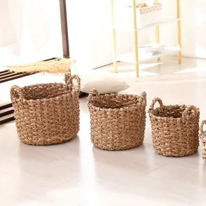 Detailed view of handmade woven straw storage baskets set, natural plant material planter pots.