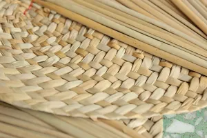 Κοντινό πλάνο υφής πλέξης χειροποίητης ψάθινης βεντάλιας, φυσικό φυτικό υλικό craft.