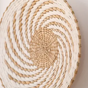 Close-up detail of a round woven wall hanging, natural straw texture and minimalist style spiral.