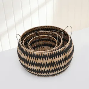 Detailed view of nested woven storage baskets with handles, natural and black geometric design.