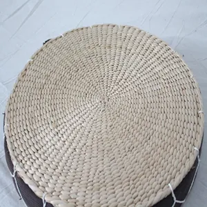 Hand-woven straw cushion detail, natural corn husk round mat texture close-up for tatami.