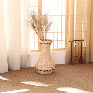 Woven rattan vase detail featuring dry reed grass for rustic home decor and interior styling.