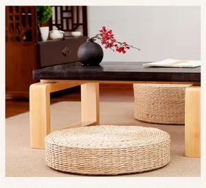 Handwoven straw meditation floor cushion detail shot, natural tatami Zen tea table setup