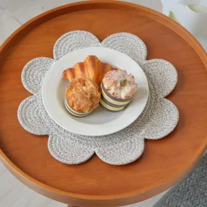 Detailed view of the cute flower-shaped woven cotton placemat on a wooden dining table.