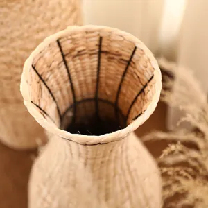 Handmade woven straw flower vase detail view, natural rattan decorative container for dried flowers.