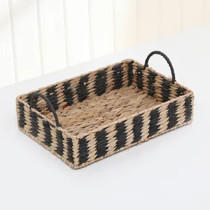 Handcrafted straw storage basket with handles, black and white striped woven design for home organization.