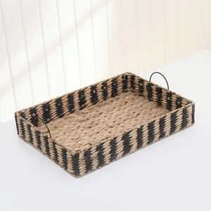 Detailed close-up view of the black and natural woven straw storage basket with handle.