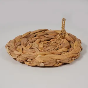 Handcrafted water hyacinth woven round table mat detail showing natural plant fiber texture and loop.