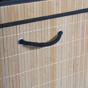 Detailed view of bamboo storage basket with black rope handle and fabric trim.