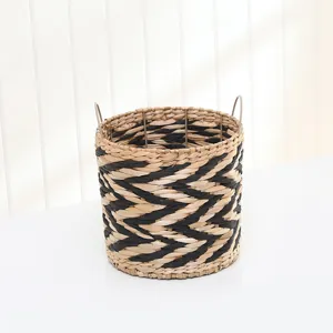 Round woven storage basket with black pattern and metal handles for home organization.